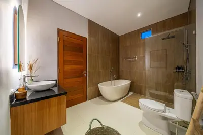 a bathroom with a tub and a toilet and a sink at Sunterra 2 - Bali Villa Dream with Huge Pool in Kerobokan