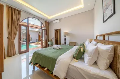 a bedroom with a bed with a green comforter at Sunterra 2 - Bali Villa Dream with Huge Pool in Kerobokan