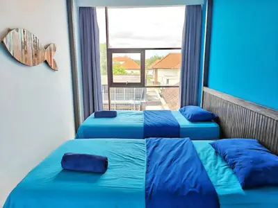 two blue beds in a room with a large window at Large Villa Jimbaran With Pool & WiFi by 2ndHome in Jimbaran