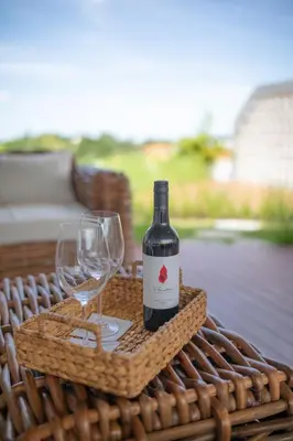 a bottle of wine and a glass on a table at Aura Umalas - Futuristic 2BR Rooftop Villa with Green Views in Kerobokan
