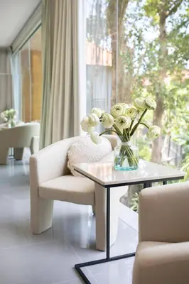 a vase of flowers on a table in a living room at Aura Umalas - Futuristic 2BR Rooftop Villa with Green Views in Kerobokan