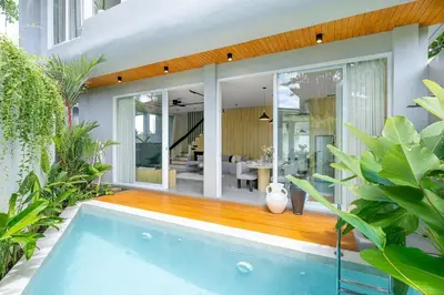 a house with a swimming pool and a dining room at Aura Umalas - Futuristic 2BR Rooftop Villa with Green Views in Kerobokan