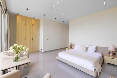 a white bedroom with a large bed and a table at Aura Umalas - Futuristic 2BR Rooftop Villa with Green Views in Kerobokan