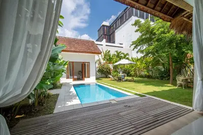 a backyard with a swimming pool and a house at 3BR Green Oasis downtown Berawa Canggu in Canggu