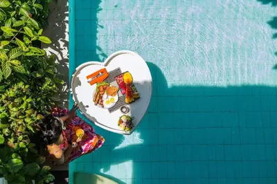 a heart shaped plate of food next to a swimming pool at The Cottage By Selasih in Seminyak