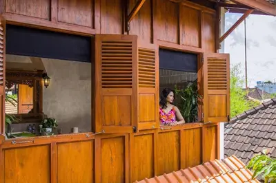 a woman looking out of a window of a house at The Cottage By Selasih in Seminyak