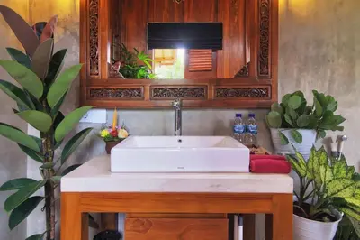 a bathroom with a white sink and some plants at The Cottage By Selasih in Seminyak