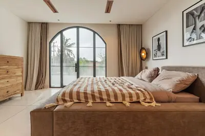 a bedroom with a large bed and a large window at Elegant 4BR Villa downtown Berawa Canggu in Canggu