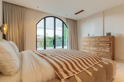 a bedroom with a large bed and a large window at Elegant 4BR Villa downtown Berawa Canggu in Canggu