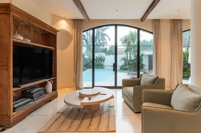 a living room with a tv and a couch and a table at Elegant 4BR Villa downtown Berawa Canggu in Canggu