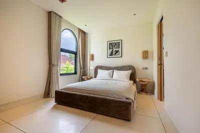 a bedroom with a large bed and a window at Elegant 4BR Villa downtown Berawa Canggu in Canggu