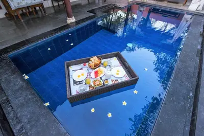 a table with eggs and food in a swimming pool at Private Pool Villas Kuta Bali in Badung