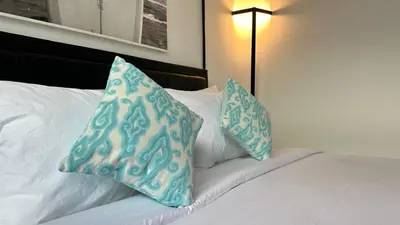 a bed with two blue pillows on top of it at 2 Bedrooms Villa Petitenget Private Pool in Seminyak
