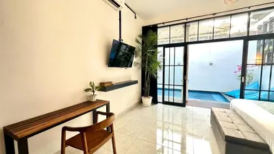 a living room with a tv and a couch and a table at 2 Bedrooms Villa Petitenget Private Pool in Seminyak