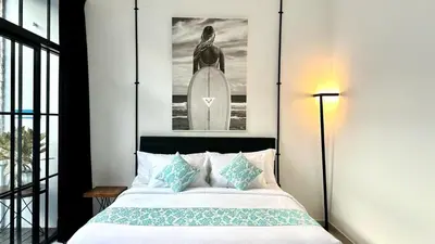 a bedroom with a bed and a picture of a surfer at 2 Bedrooms Villa Petitenget Private Pool in Seminyak