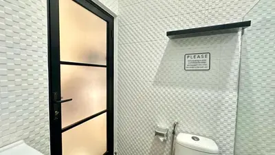 a bathroom with a toilet and a door with a sign at 2 Bedrooms Villa Petitenget Private Pool in Seminyak