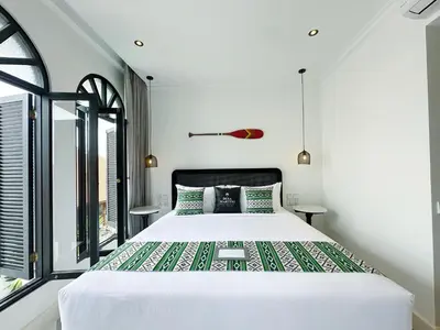 a bedroom with a large white bed and windows at Martini Beachside Villa 5 in Canggu
