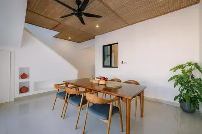 a dining room with a ceiling fan and a wooden table and chairs at Villa Batu Putih 3 Seminyak in Seminyak