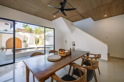 a dining room with a wooden table and chairs at Villa Batu Putih 3 Seminyak in Seminyak