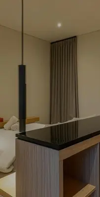 a bedroom with a bed and a black counter top at Cocon Maison Timal in Kerobokan