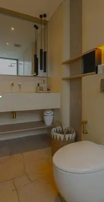 a bathroom with a toilet and a sink at Cocon Maison Timal in Kerobokan