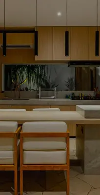 a kitchen with wooden cabinets and white stools at Cocon Maison Timal in Kerobokan