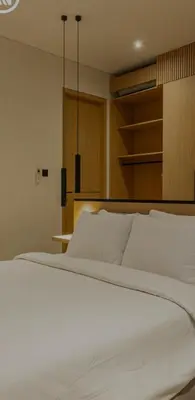 a bedroom with a white bed and a shelf at Cocon Maison Timal in Kerobokan