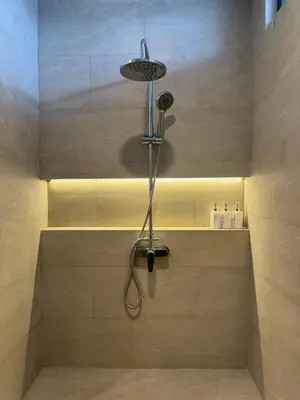 a shower with a shower head in a bathroom at Family Haven 6BR Luxe Villa in Berawa, Canggu in Canggu