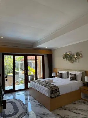 a bedroom with a large bed and a balcony at Mara inn in Nusa Dua