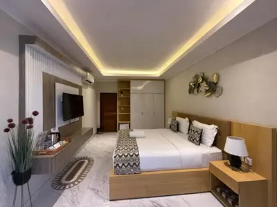 a bedroom with a large bed and a television at Mara inn in Nusa Dua