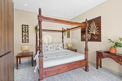a bedroom with a canopy bed and a table at Andrew Villa by Kozystay - Umalas in Canggu