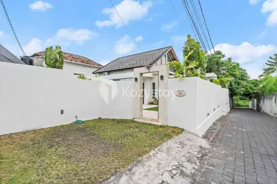 a house with a white wall and a driveway at Andrew Villa by Kozystay - Umalas in Canggu
