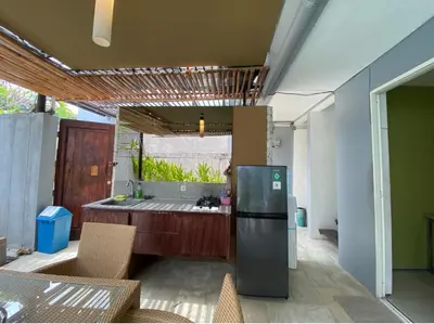 a kitchen with a refrigerator and a table with chairs at 2 bedroom with pool tropical in Nusa Dua