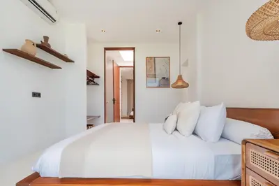 a bedroom with a white bed with white pillows at Casa Nalani in Bali in Kerobokan