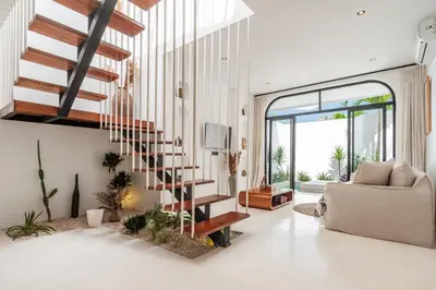 a living room with a spiral staircase in a house at Casa Nalani in Bali in Kerobokan