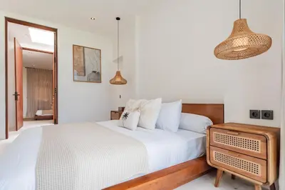a bedroom with a large white bed and a mirror at Casa Nalani in Bali in Kerobokan