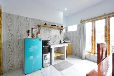 a kitchen with a blue refrigerator and a table at Kamar Kodel2 Apt in Seminyak