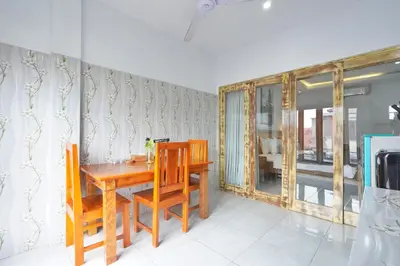 a dining room with a wooden table and chairs at Kamar Kodel2 Apt in Seminyak