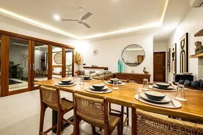 a dining room with a large wooden table and chairs at Brand new - spacious complex Villas Virland - center Seminyak in Seminyak