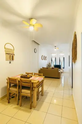 a dining room with a table and a couch at Villa Cempaka - Pemogan in Denpasar