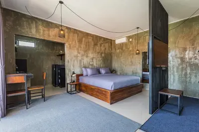 a bedroom with a bed and a desk and a television at ChinGiack Apartments Canggu Pool and Terrace in Canggu