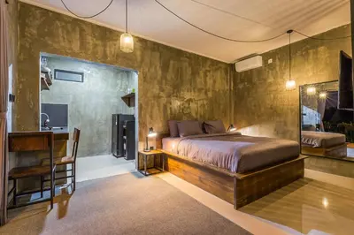 a bedroom with a bed and a desk and a mirror at ChinGiack Apartments Canggu Pool and Terrace in Canggu