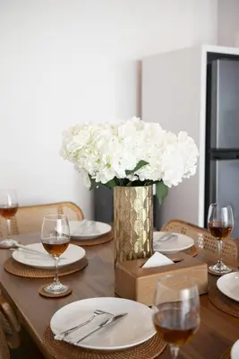 a wooden table with a vase of white flowers at Villa Esha I in Seminyak