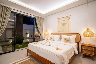 a bedroom with a bed and a large window at Villa Esha I in Seminyak