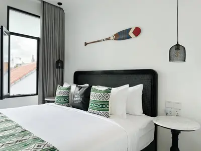 a bedroom with a bed with pillows and a table at Martini Beachside Villa 6 in Canggu