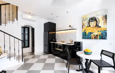 a kitchen with a table and a painting on the wall at Martini Beachside Villa 6 in Canggu