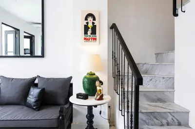 a living room with a couch and a staircase at Martini Beachside Villa 6 in Canggu