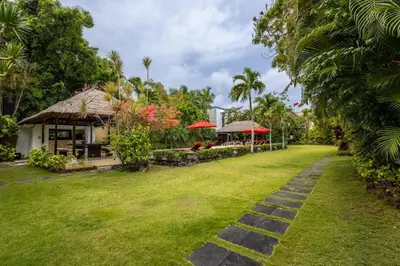 a garden with a house and a path at 5 Bedroom Luxury Villa With Huge Garden & Pool 150-Metres To Seminyak Beach in Seminyak