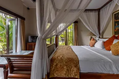 a bedroom with a bed with curtains and a window at 5 Bedroom Luxury Villa With Huge Garden & Pool 150-Metres To Seminyak Beach in Seminyak