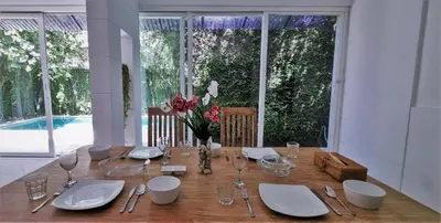 a dining table with plates and glasses and a vase of flowers at Tropical 2br private pool Villa in central Seminyak in Seminyak